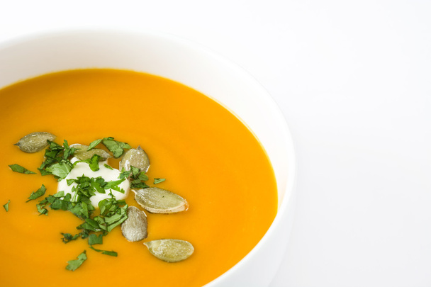 カボチャのスープと白い背景に分離されたカボチャの種 - 写真・画像
