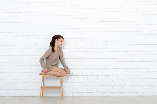 Beautiful brunette woman with wooden chair - Foto, Bild