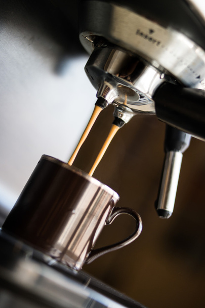 cafetera espresso haciendo café y vertiendo en una taza marrón
 - Foto, imagen