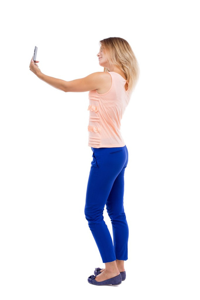 back view of standing young beautiful  woman  and using a mobile - Foto, Imagem