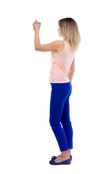 back view of standing young beautiful  woman  and using a mobile - Photo, image