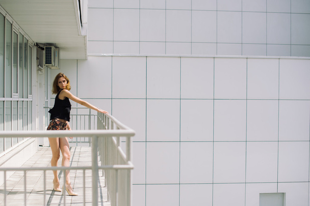 beautiful slim girl in shorts and t-shirt standing on bolkone looking into the distance - Φωτογραφία, εικόνα