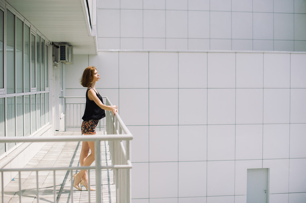 beautiful slim girl in shorts and t-shirt standing on bolkone looking into the distance - Φωτογραφία, εικόνα