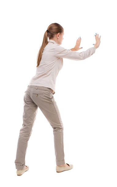back view of woman pushes wall. - Photo, Image