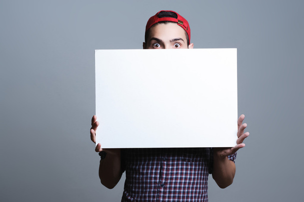 Young man holding blank paper - Zdjęcie, obraz