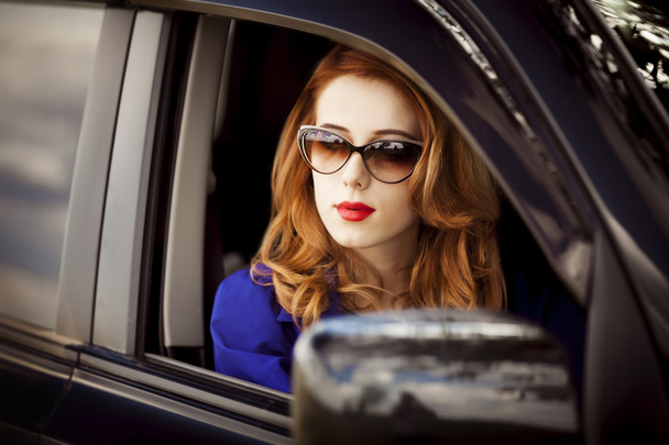 Beautiful redhead woman in the car. - Zdjęcie, obraz