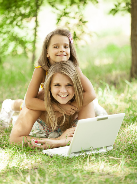 Two sisters with laptop in the park. - Photo, Image