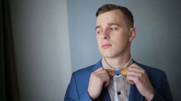 Close-up of a gentleman straightens his wooden bowtie. - Footage, Video
