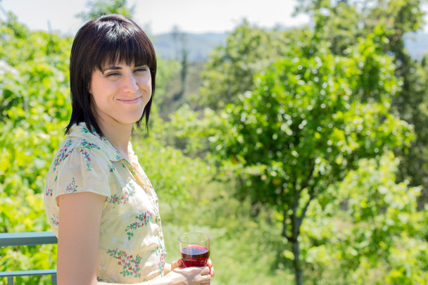 Frau trinkt Rotwein in einem Weinberg, im Freien - Foto, Bild