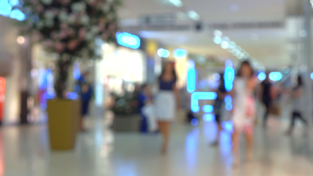Unbekannte gehen in modernes Einkaufszentrum. 4k-Bokeh-Video - Filmmaterial, Video