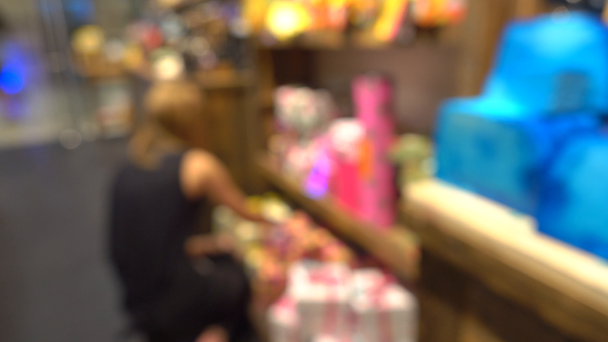 Felismerhetetlen elárusítónő dekorációs kozmetikai bolt kirakat. 4 k bokeh videóinak - Felvétel, videó