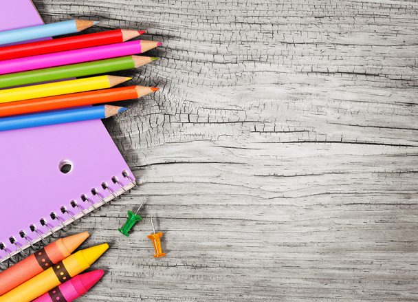 Education supplies on old wooden background. Colorful pencils, n - Foto, immagini