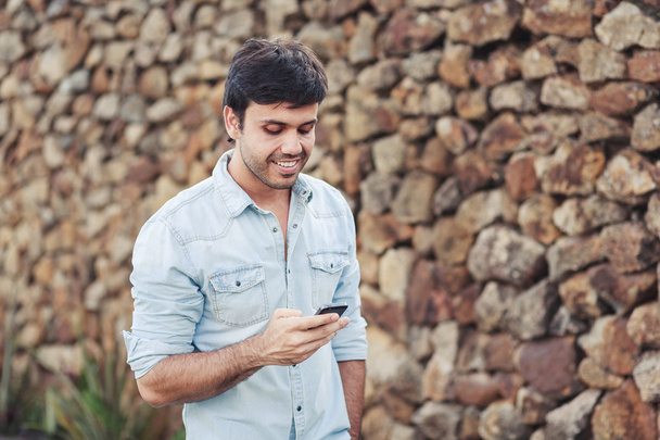 Outdoor portrait of modern young man with mobile phone in the street - Photo, Image