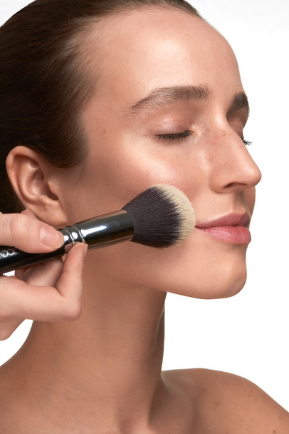 Beautiful young woman makeup closeup process - Photo, image