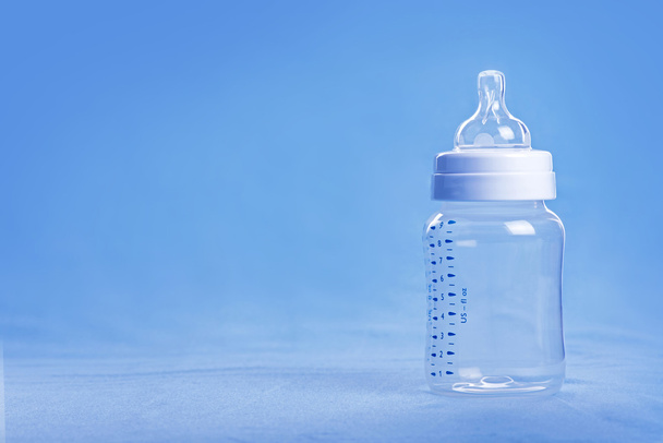 Vauvan maitopullo sinisellä levyllä
 - Valokuva, kuva