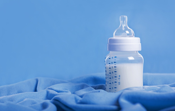 Bottiglia di latte per bambini su un foglio blu
 - Foto, immagini