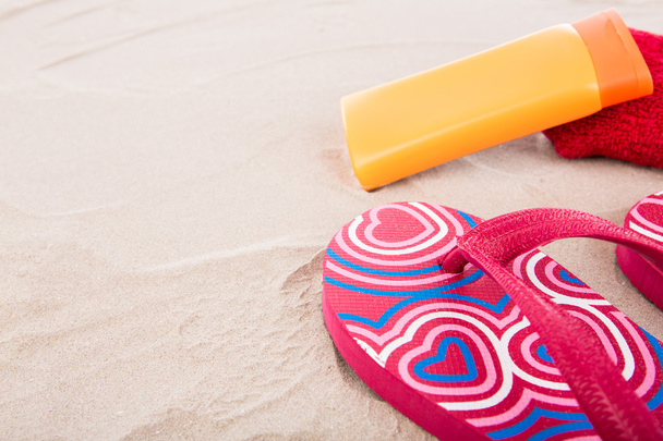 Flipflops ,sunscreen,towel on sand beach - Photo, Image