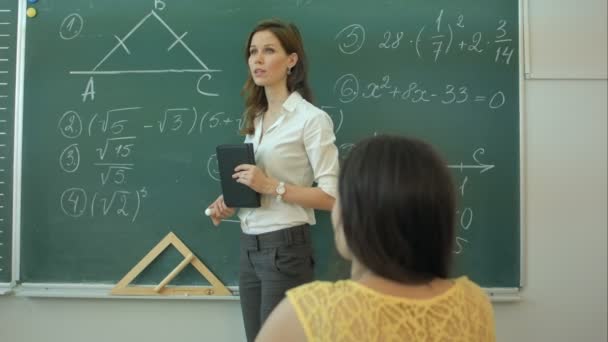 Clever confident female student in the classroom writing on a chalkboard math - Séquence, vidéo