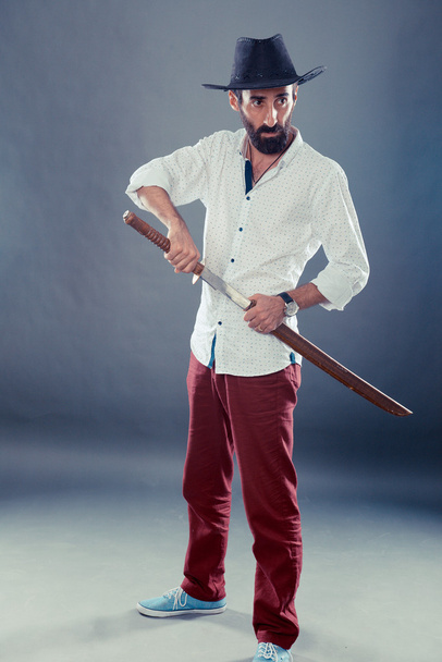 Man in casual dress code with hat and katana - Foto, Imagen