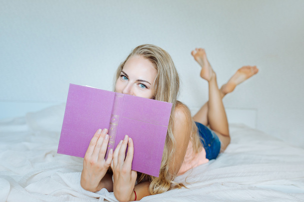 The girl on the bed with a book - Foto, immagini