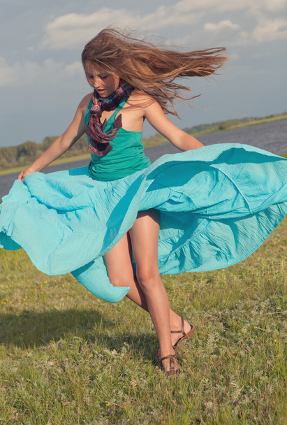 Chica alegre girando en el campo verde, verano
 - Foto, imagen