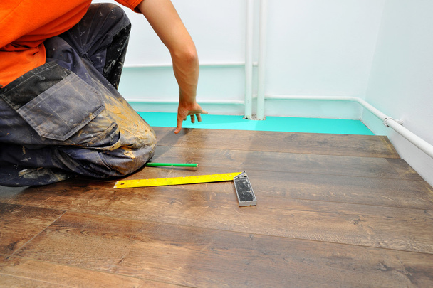 Carpintero haciendo trabajo de piso laminado
 - Foto, imagen