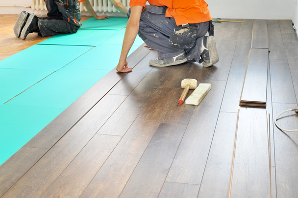 Carpintero haciendo trabajo de piso laminado
 - Foto, Imagen