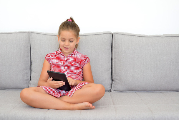 Αξιολάτρευτο κορίτσι μάθησης με την συσκευή tablet - Φωτογραφία, εικόνα