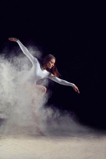 Ballerina dancing with flour on a black background - Φωτογραφία, εικόνα