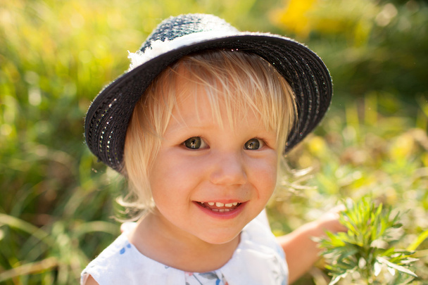 Little blonde girl in blue hat - Foto, Bild