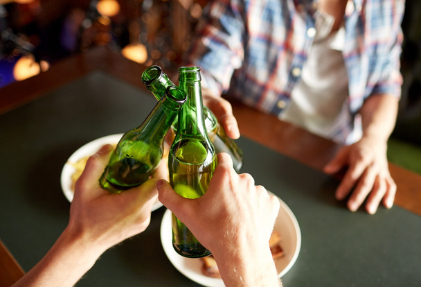 close up of friends drinking beer at bar or pub - Foto, Imagen