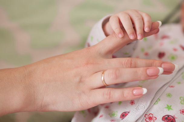 Son and mother, baby holding moms finger. Family concept - Фото, зображення
