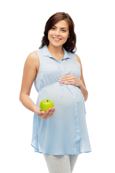 happy pregnant woman holding green apple - Fotó, kép