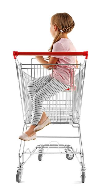 Cute girl sitting in shopping cart - Valokuva, kuva