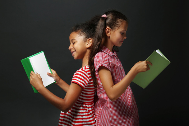 Meninas bonitos leitura livro no fundo cinza
 - Foto, Imagem