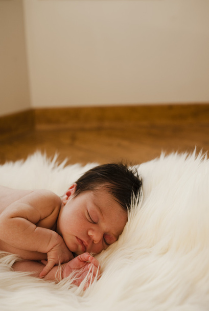 Recém-nascido dormindo em um cobertor no chão
 - Foto, Imagem