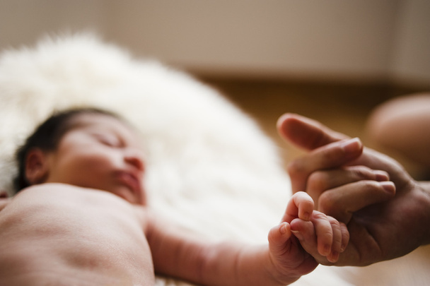 pasgeboren vangen de vinger van haar moeder - Foto, afbeelding