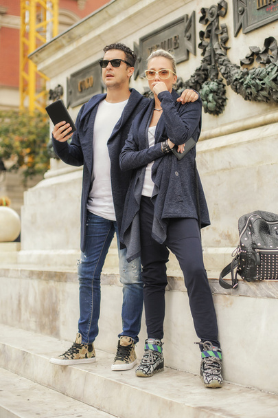 Beautiful couple with tablet in the city - Фото, изображение