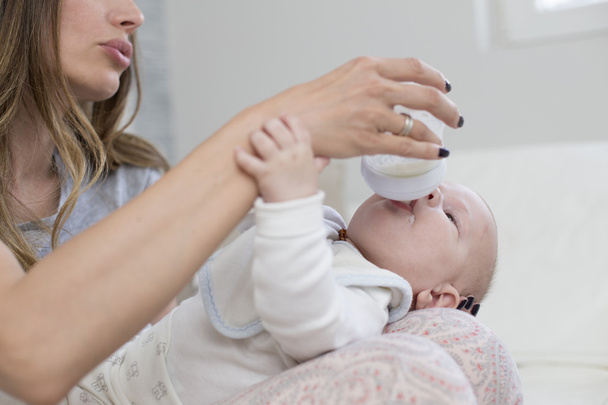 vauva juo maitoa pullosta
 - Valokuva, kuva