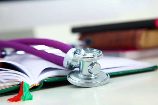Stethoscope lying on a table an open book - Photo, Image