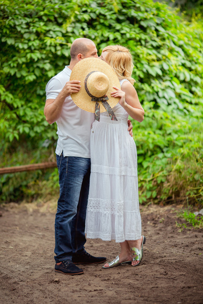 raskaana oleva nainen miehensä kanssa puutarhassa
 - Valokuva, kuva