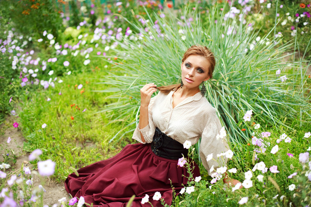 Fashion girl enjoying a summer day in flower garden - Фото, зображення