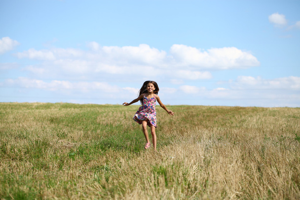 Beautiful young little girl running summer field - Фото, зображення