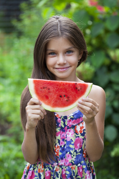 Portrait of a young little girl with watermelon - Photo, Image