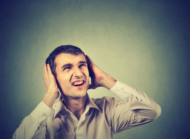 annoyed stressed man covering ears, looking up, stop making loud noise - Foto, Imagen