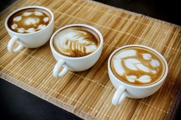 Three cups of cafe' latte with three shapes of latte art  - Photo, Image