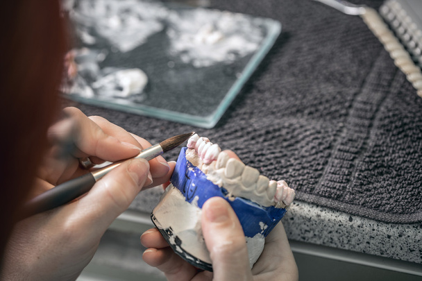 Woman hand painting denture - Photo, Image