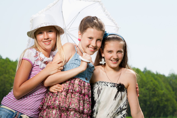 drei glückliche junge Freundinnen unter einem Regenschirm - Foto, Bild