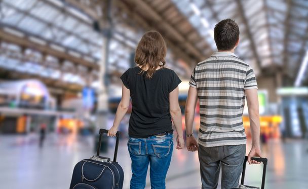 Νεαρό ζευγάρι ταξιδεύουν για διακοπές. Άνδρας και γυναίκα με αποσκευές σε σιδηροδρομικό σταθμό. - Φωτογραφία, εικόνα