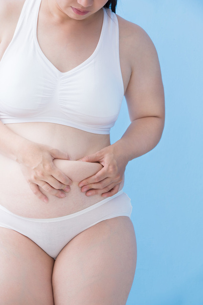 woman evaluating fat under skin - Foto, imagen